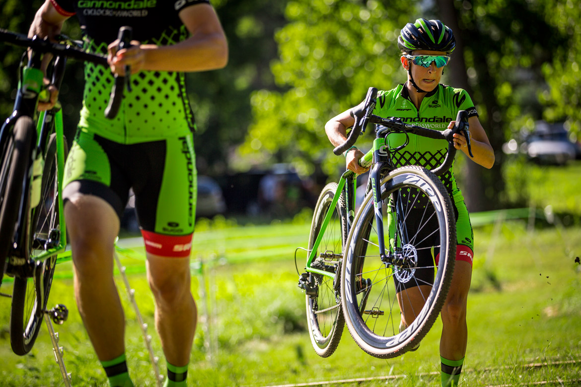 carrying cyclocross bike over a hurdle