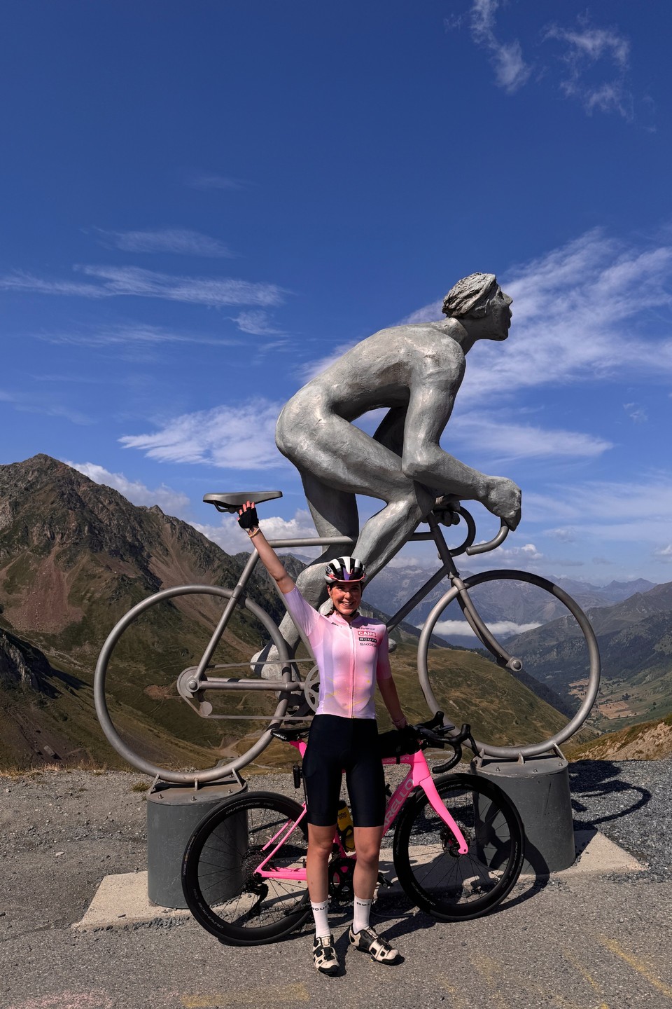 Amy Hudson In Front Of A Cyclist Sculpture With Pink Pinarello