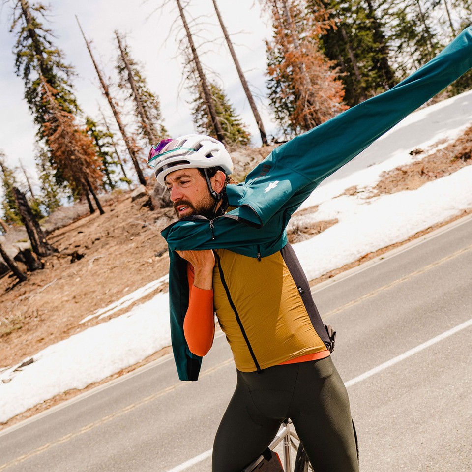 Male Cyclist Putting On Jackey